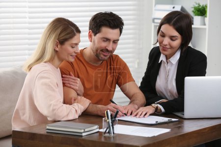 Téléchargez les photos : Professional notary helping couple with paperwork in office - en image libre de droit