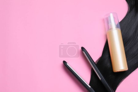 Photo for Spray bottle with thermal protection, iron and lock of black hair on pink background, flat lay. Space for text - Royalty Free Image