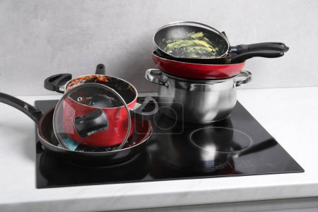 Téléchargez les photos : Stacks of dirty kitchenware on cooktop in kitchen - en image libre de droit