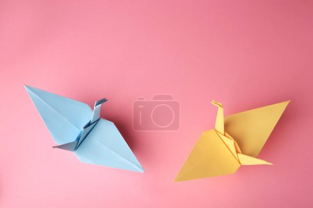 Foto de Origami art. Colorful handmade paper cranes on pink background, flat lay. Space for text - Imagen libre de derechos