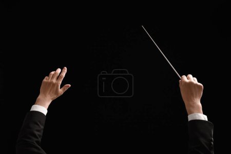 Foto de Back view of professional conductor with baton on black background, closeup - Imagen libre de derechos