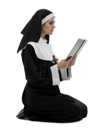 Téléchargez les photos : Young nun reading Bible on white background - en image libre de droit
