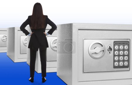 Photo for Financial security, keeping money. Businesswoman and many big steel safes on white background - Royalty Free Image