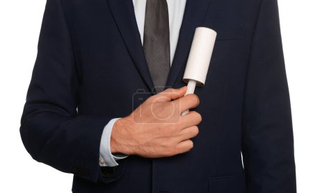 Téléchargez les photos : Man cleaning jacket with adhesive lint roller on white background, closeup - en image libre de droit