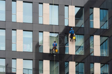 Photo for Men washing windows on modern building outdoors - Royalty Free Image