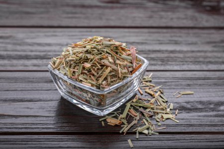 Téléchargez les photos : Glass bowl with aromatic dried lemongrass on wooden table - en image libre de droit