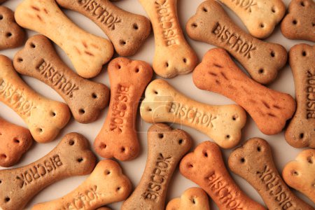 Téléchargez les photos : Bone shaped dog cookies on beige background, flat lay - en image libre de droit