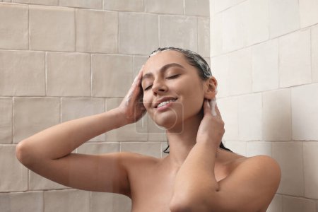 Téléchargez les photos : Happy woman washing hair while taking shower at home - en image libre de droit