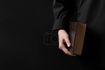 Téléchargez les photos : Woman with holy Bible on black background, closeup. Space for text - en image libre de droit