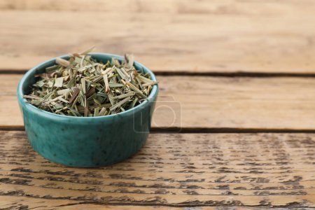 Téléchargez les photos : Bowl with aromatic dried lemongrass on wooden table, space for text - en image libre de droit