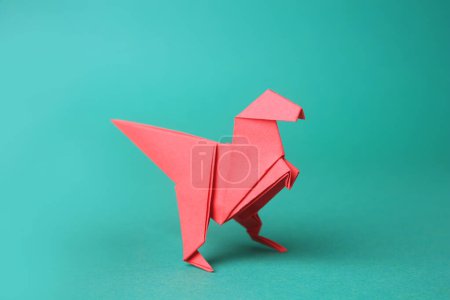 Photo for Origami art. Handmade red paper dinosaur on turquoise background - Royalty Free Image