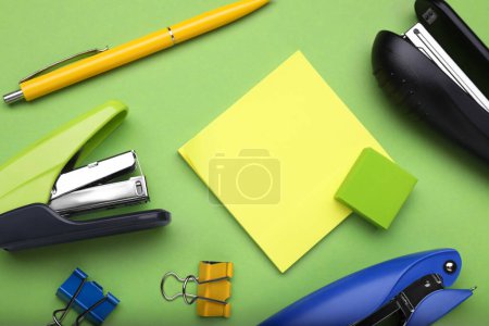 Photo for Flat lay composition with new staplers on green background - Royalty Free Image