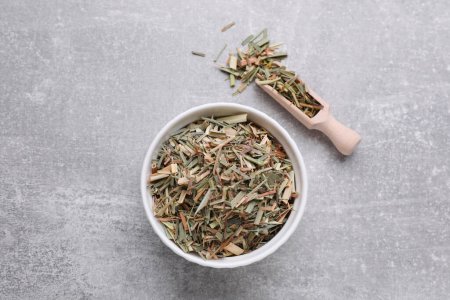 Téléchargez les photos : Bowl and scoop with aromatic dried lemongrass on light grey table, flat lay - en image libre de droit
