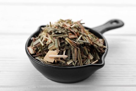 Téléchargez les photos : Small saucepan with aromatic dried lemongrass on white wooden table, closeup - en image libre de droit