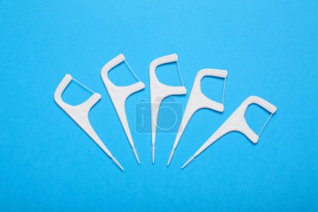 Photo for Dental flossers on light blue background, flat lay - Royalty Free Image