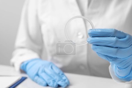 Téléchargez les photos : Doctor holding diaphragm vaginal contraceptive ring at table, closeup - en image libre de droit