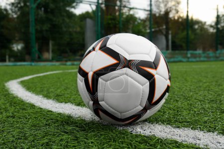 Téléchargez les photos : Nouveau ballon de football sur terrain de football vert - en image libre de droit