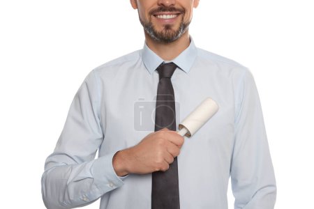 Téléchargez les photos : Man cleaning shirt with adhesive lint roller on white background, closeup - en image libre de droit