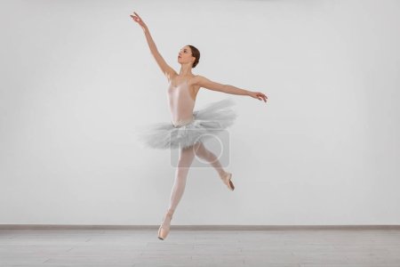 Young ballerina practicing dance moves in studio