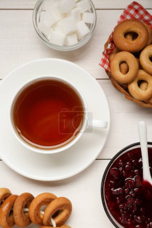 Téléchargez les photos : Flat lay composition with delicious ring shaped Sushki (dry bagels) and cup of tea on white wooden table - en image libre de droit