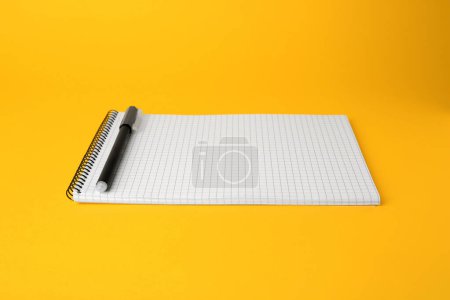 Photo for Notepad with erasable pen on yellow background - Royalty Free Image