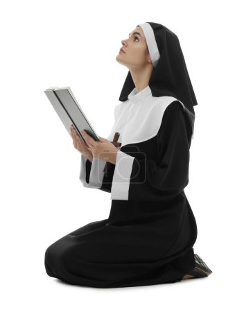 Téléchargez les photos : Jeune religieuse avec la Bible priant Dieu sur fond blanc - en image libre de droit