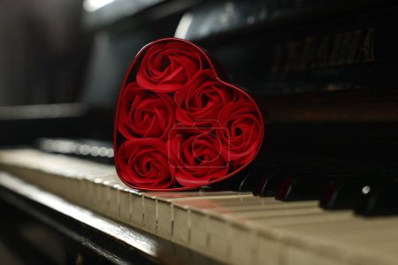 Foto de Hermosas rosas rojas en forma de corazón caja en teclas de piano, primer plano - Imagen libre de derechos