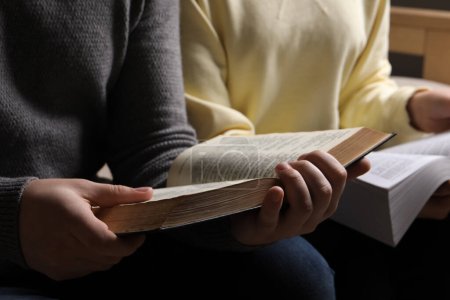 Couple reading Bibles in room, closeup view