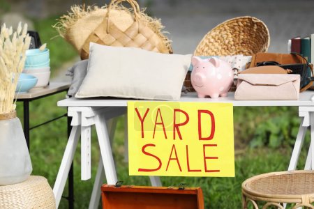 Foto de Table with different stuff and sign Yard sale outdoors - Imagen libre de derechos