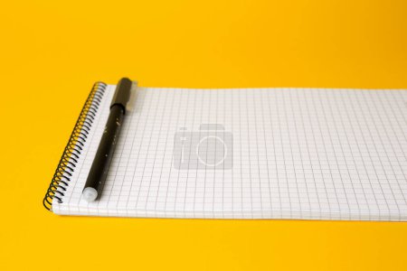 Photo for Notepad with erasable pen on yellow background, closeup - Royalty Free Image