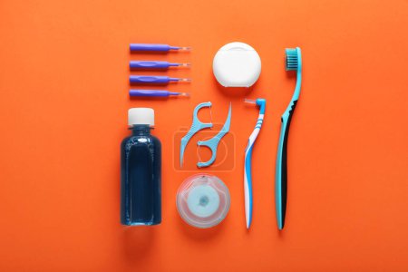 Foto de Flat lay composition with dental floss and different teeth care products on orange background - Imagen libre de derechos