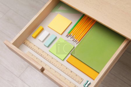Téléchargez les photos : Office supplies in open desk drawer, above view - en image libre de droit