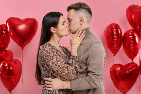 Foto de Preciosa pareja besándose sobre fondo rosa. Celebración de San Valentín - Imagen libre de derechos