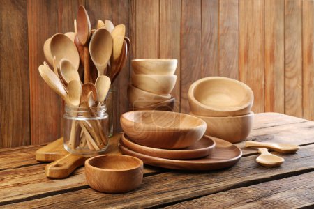 Many different wooden dishware and utensils on table