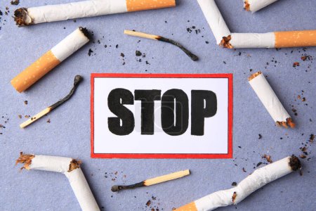Photo for Card with word Stop, cigarette waste and burnt matches on light blue background, flat lay. Quitting smoking concept - Royalty Free Image