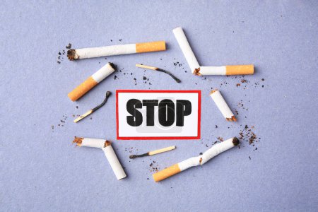 Photo for Card with word Stop, cigarette waste and burnt matches on light blue background, flat lay. Quitting smoking concept - Royalty Free Image