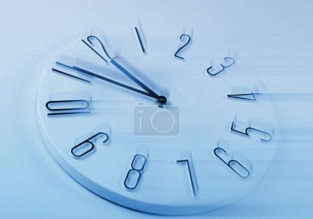 Foto de Fleeting time concept. Clock on light blue background, motion effect - Imagen libre de derechos