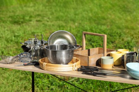 Photo for Many different items for kitchen on wooden table outdoors. Garage sale - Royalty Free Image