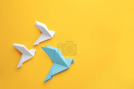 Foto de Origami art. Colorful handmade paper birds on yellow background, flat lay. Space for text - Imagen libre de derechos