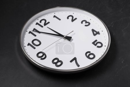 Photo for Clock showing five minutes until midnight on black table. New Year countdown - Royalty Free Image