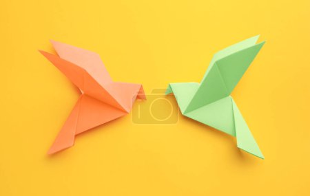 Foto de Origami art. Colorful handmade paper birds on yellow background, flat lay - Imagen libre de derechos
