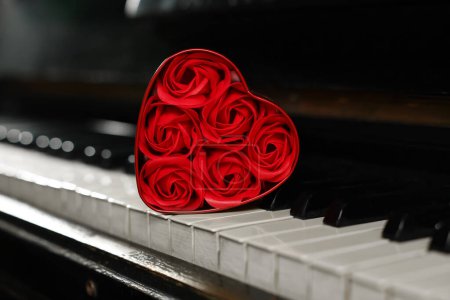 Foto de Hermosas rosas rojas en forma de corazón caja en teclas de piano, primer plano - Imagen libre de derechos