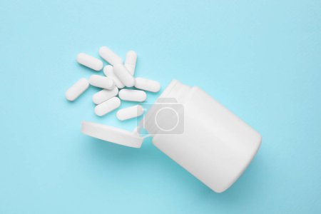 Photo for Antidepressants and medical bottle on light blue background, flat lay - Royalty Free Image