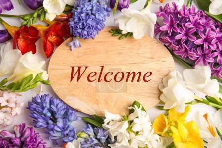 Téléchargez les photos : Welcome card. Wooden board with word surrounded by beautiful spring flowers on white background, flat lay - en image libre de droit