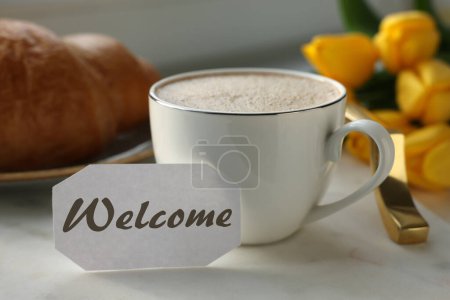 Téléchargez les photos : Welcome card, cup of aromatic coffee and croissant on tray and beautiful yellow tulips - en image libre de droit