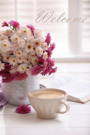 Téléchargez les photos : Carte de bienvenue. Tasse de café frais, livre ouvert et beau bouquet sur table en bois blanc près de la fenêtre - en image libre de droit