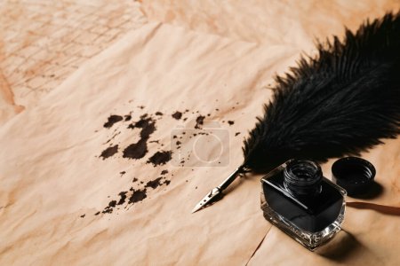 Téléchargez les photos : Open inkwell and lush feather pen on vintage parchments. Space for text - en image libre de droit