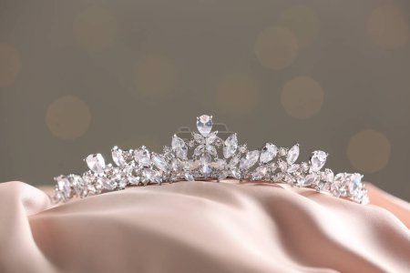 Téléchargez les photos : Beautiful silver tiara with diamonds on light cloth - en image libre de droit