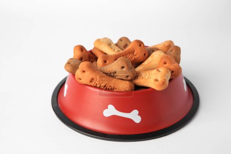 Téléchargez les photos : Bone shaped dog cookies in feeding bowl on white background - en image libre de droit