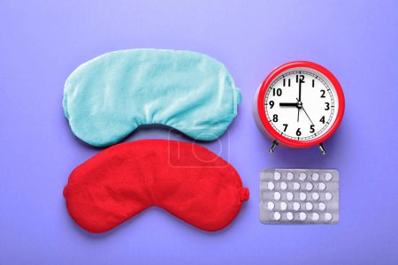 Photo for Soft sleep masks, pills and alarm clock on purple background, flat lay - Royalty Free Image